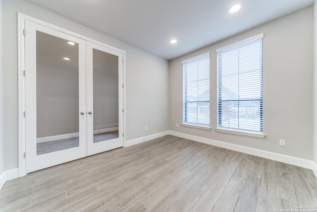 empty room featuring french doors and light wood-type flooring