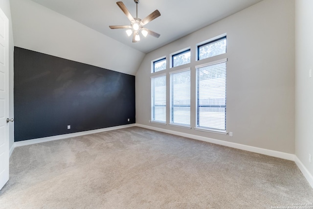 carpeted empty room featuring lofted ceiling and ceiling fan