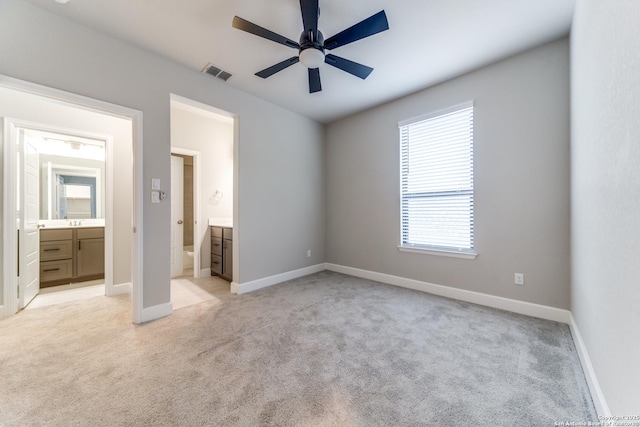 unfurnished bedroom featuring ensuite bath and light colored carpet