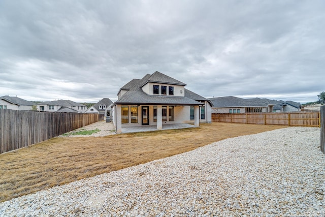 rear view of property featuring a patio and a yard