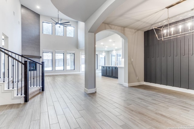 entryway with sink, ceiling fan with notable chandelier, and light wood-type flooring