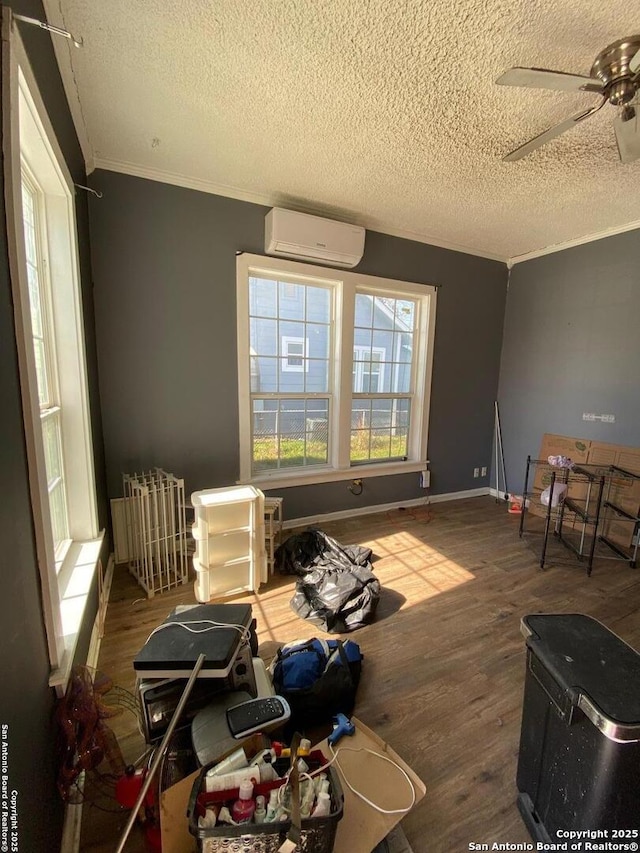 misc room featuring hardwood / wood-style flooring, crown molding, a wall mounted AC, and ceiling fan