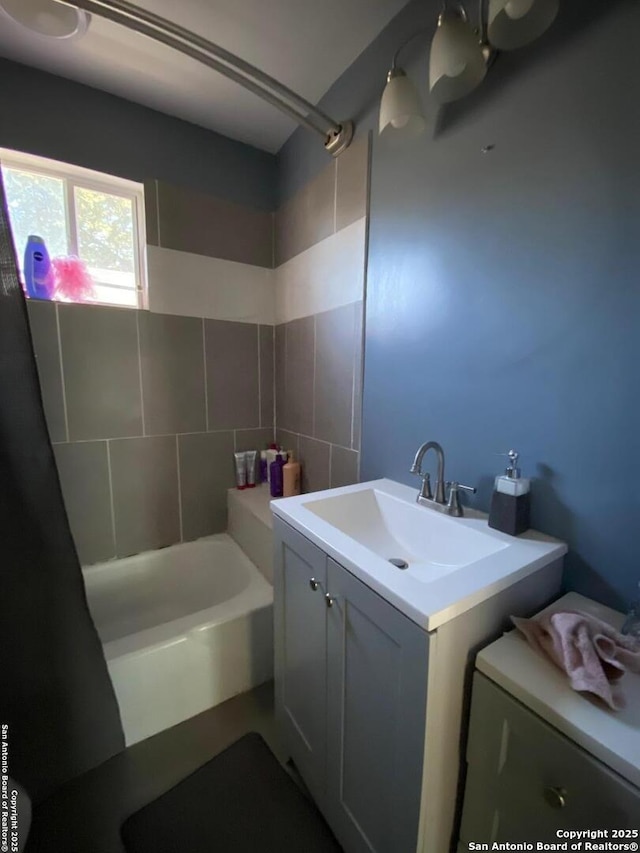 bathroom with tiled shower / bath and vanity