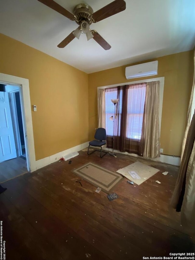 empty room with hardwood / wood-style flooring, ceiling fan, and a wall mounted AC