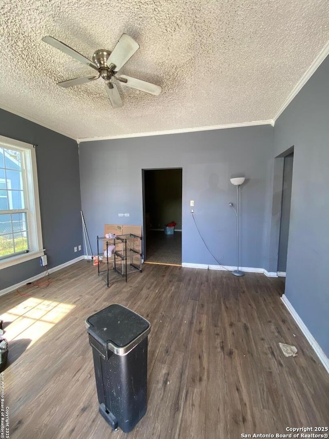 interior space with crown molding, dark wood-type flooring, ceiling fan, and a textured ceiling