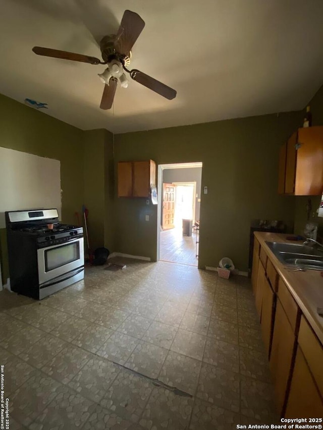 kitchen featuring sink, gas range, and ceiling fan