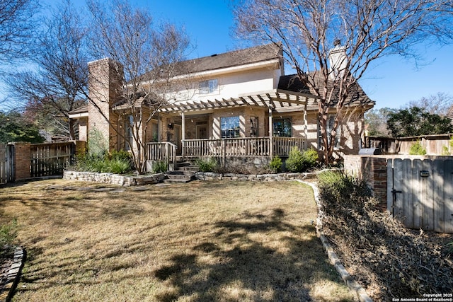 back of property featuring a yard and a pergola