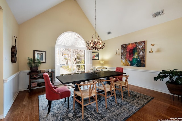 dining space with high vaulted ceiling, a notable chandelier, and dark hardwood / wood-style flooring