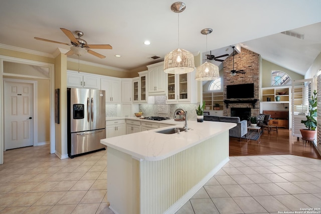 kitchen with appliances with stainless steel finishes, sink, white cabinets, hanging light fixtures, and kitchen peninsula