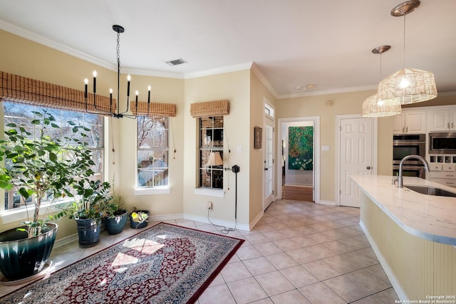 kitchen with crown molding, stainless steel appliances, sink, and hanging light fixtures