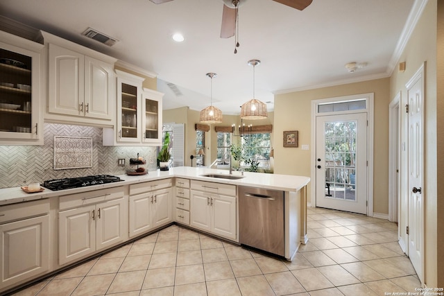 kitchen featuring pendant lighting, light tile patterned floors, appliances with stainless steel finishes, ornamental molding, and decorative backsplash