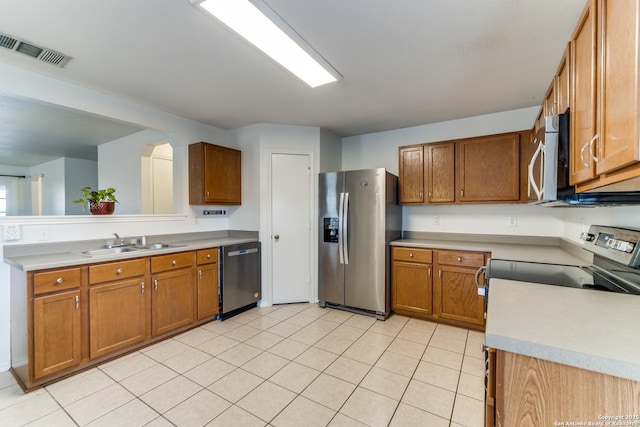 kitchen featuring stainless steel appliances, sink, and light tile patterned floors