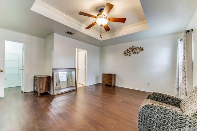 sitting room with crown molding, dark wood-type flooring, ceiling fan, and a tray ceiling