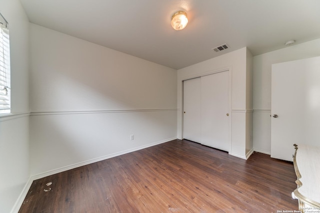 unfurnished bedroom featuring dark hardwood / wood-style floors and a closet