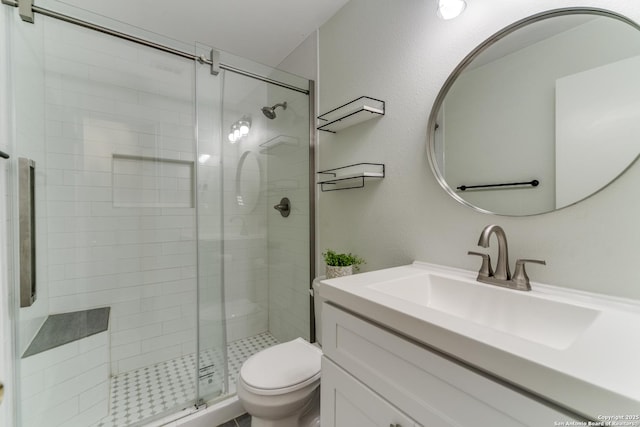 bathroom with vanity, toilet, and a shower with door