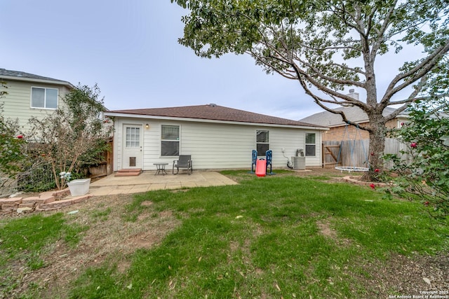 back of house with cooling unit, a lawn, and a patio