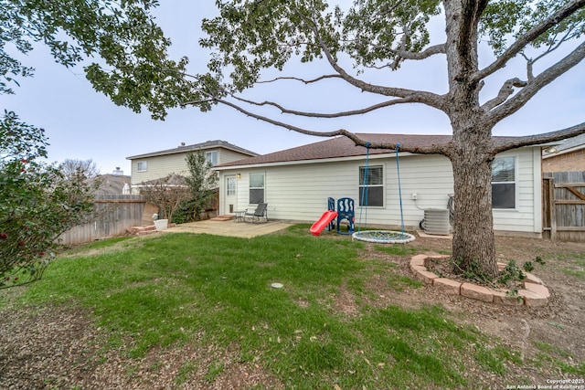 rear view of house with central AC unit, a yard, and a patio area