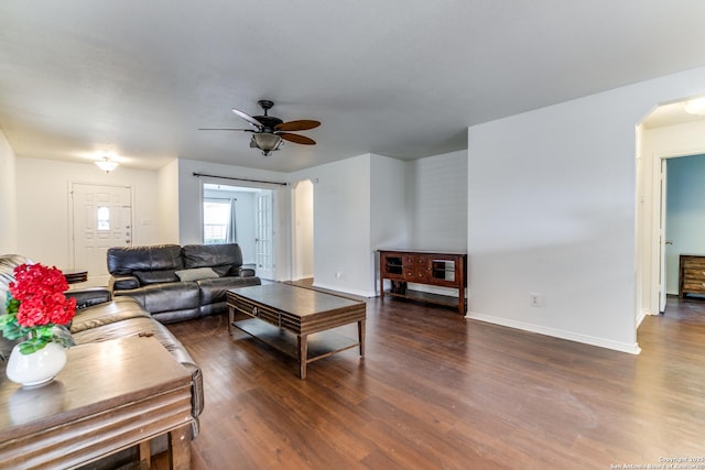 living room featuring ceiling fan and dark hardwood / wood-style flooring