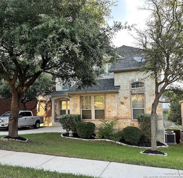 view of front facade with cooling unit and a front yard