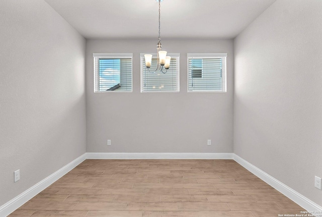 unfurnished room with light hardwood / wood-style floors and a chandelier