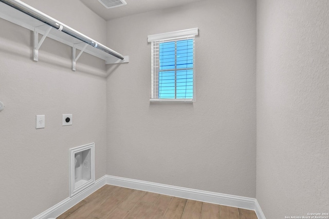 washroom with hardwood / wood-style flooring and hookup for an electric dryer