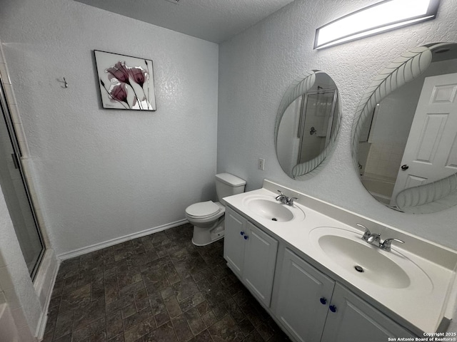 bathroom with vanity, toilet, a textured ceiling, and walk in shower