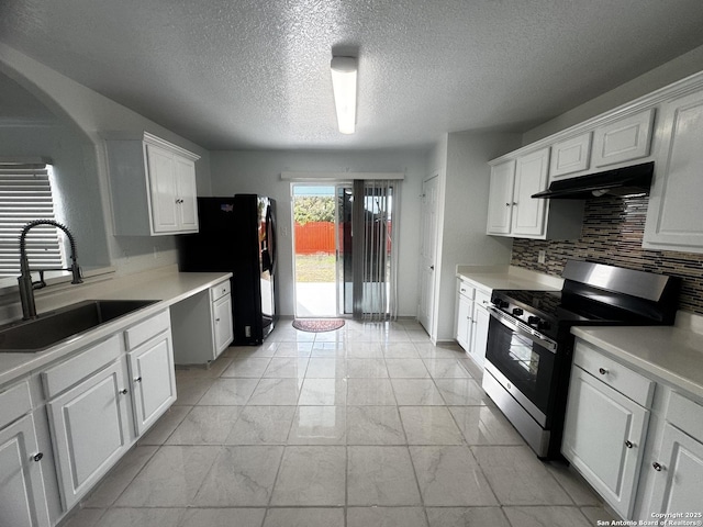 kitchen featuring black fridge, sink, range with gas cooktop, and white cabinets