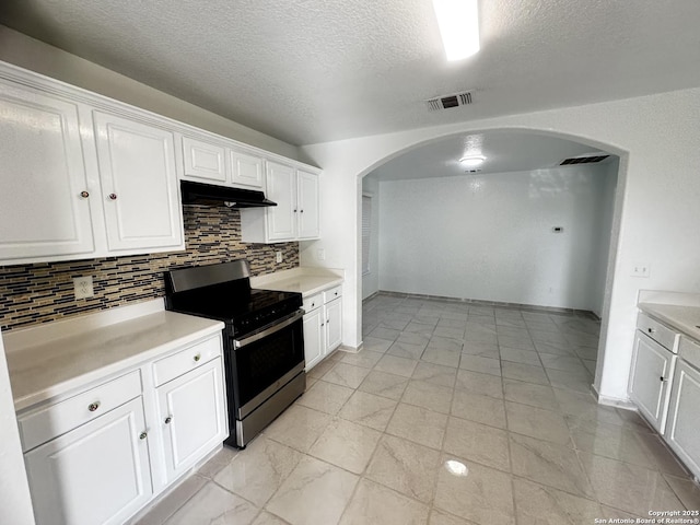 kitchen with tasteful backsplash, stainless steel stove, a textured ceiling, and white cabinets