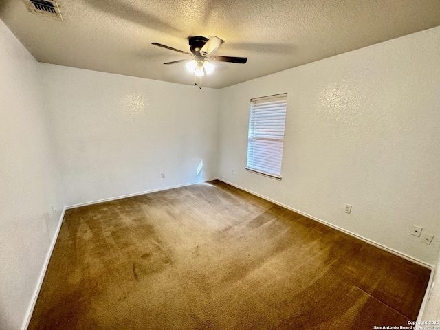 carpeted empty room with ceiling fan and a textured ceiling