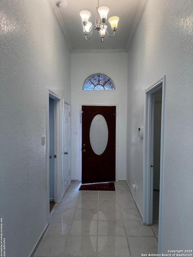 doorway featuring crown molding, a chandelier, and light tile patterned floors