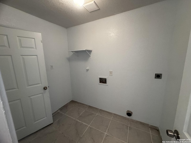 laundry room with hookup for a washing machine, electric dryer hookup, and a textured ceiling