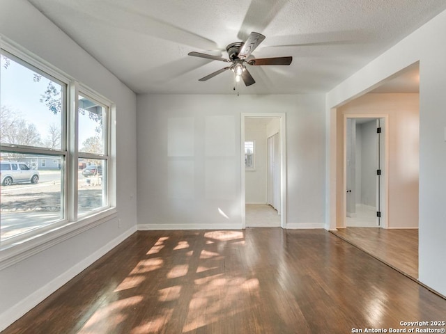 empty room featuring ceiling fan, dark hardwood / wood-style floors, and a textured ceiling