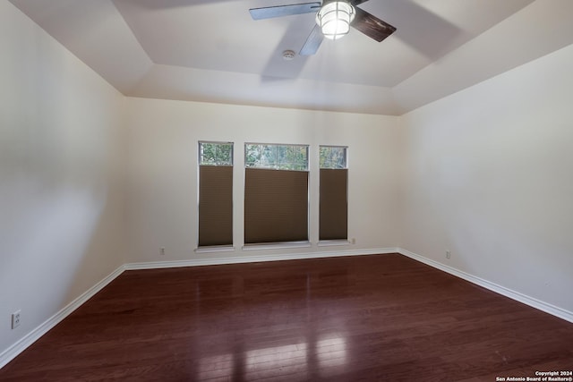 spare room with ceiling fan, dark hardwood / wood-style flooring, and a tray ceiling