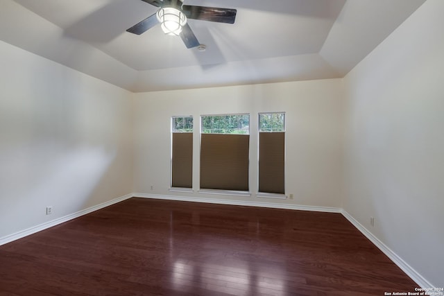 spare room with dark hardwood / wood-style flooring, vaulted ceiling, and ceiling fan