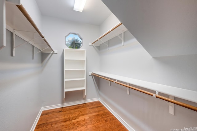 walk in closet with hardwood / wood-style floors