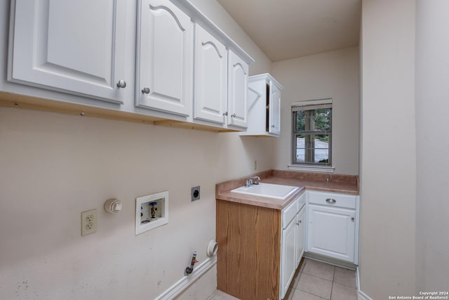 clothes washing area featuring sink, gas dryer hookup, cabinets, electric dryer hookup, and washer hookup