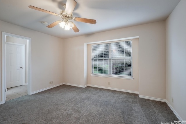 carpeted empty room featuring ceiling fan