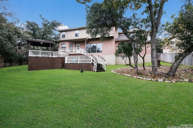 back of property with a wooden deck and a yard