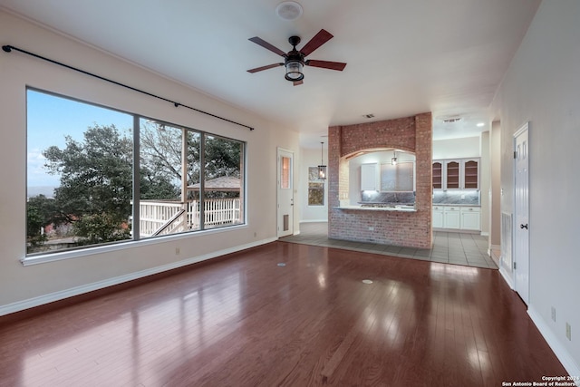 unfurnished living room with ceiling fan and dark hardwood / wood-style flooring