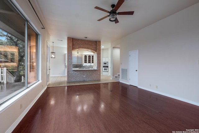 unfurnished living room with wood-type flooring and ceiling fan