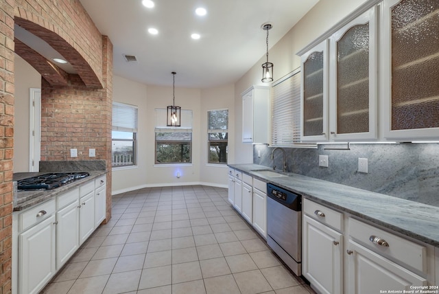 kitchen with sink, hanging light fixtures, stainless steel appliances, light stone countertops, and white cabinets