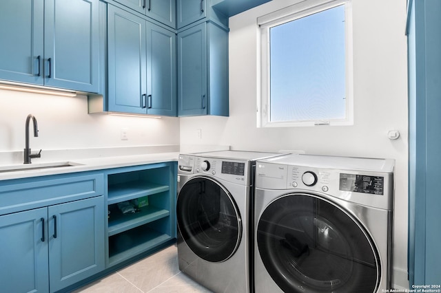 laundry room featuring sink, cabinets, washing machine and clothes dryer, and light tile patterned flooring