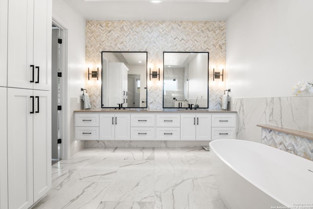 bathroom featuring a tub to relax in, vanity, and tile walls