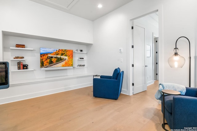 sitting room featuring built in features and light wood-type flooring