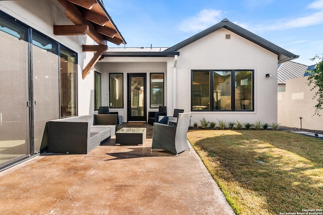 rear view of property featuring outdoor lounge area, a patio, and a lawn