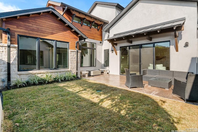 rear view of house featuring an outdoor living space, a yard, and a patio