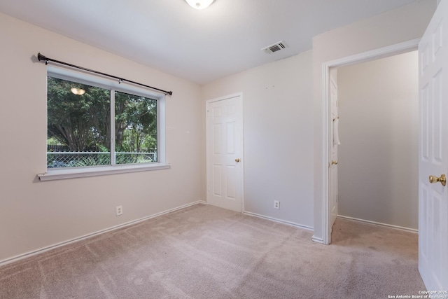 unfurnished bedroom featuring light carpet