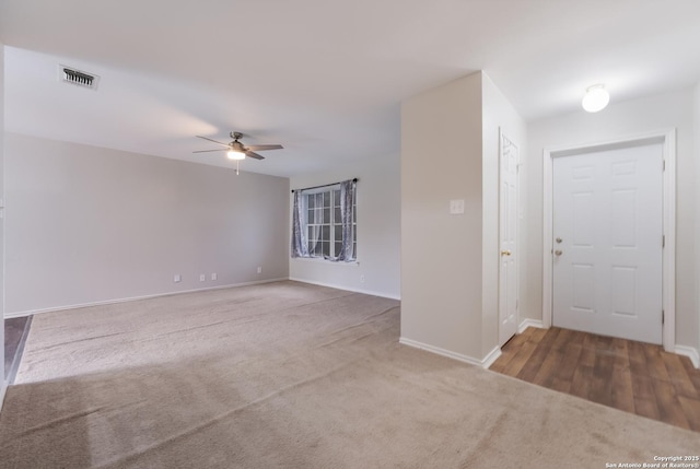 carpeted spare room featuring ceiling fan