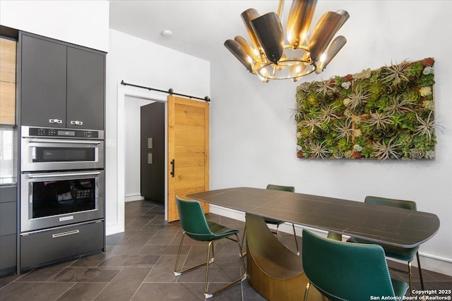 dining room featuring an inviting chandelier and a barn door