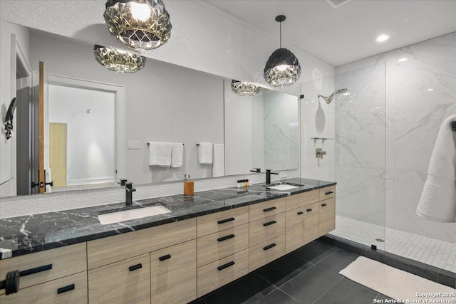 bathroom with vanity, tile patterned flooring, and a tile shower